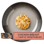 plate with dog food chicken with ham and vegetables