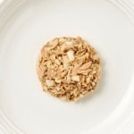Isolated aerial image of Encore fillet of tuna cat food with seabream on a plate