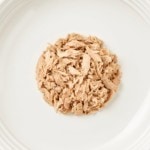Aerial image of Encore's fillet of tuna cat food with crab in broth on a plate